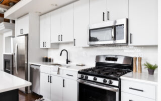 A white kitchen with stainless steel appliances.