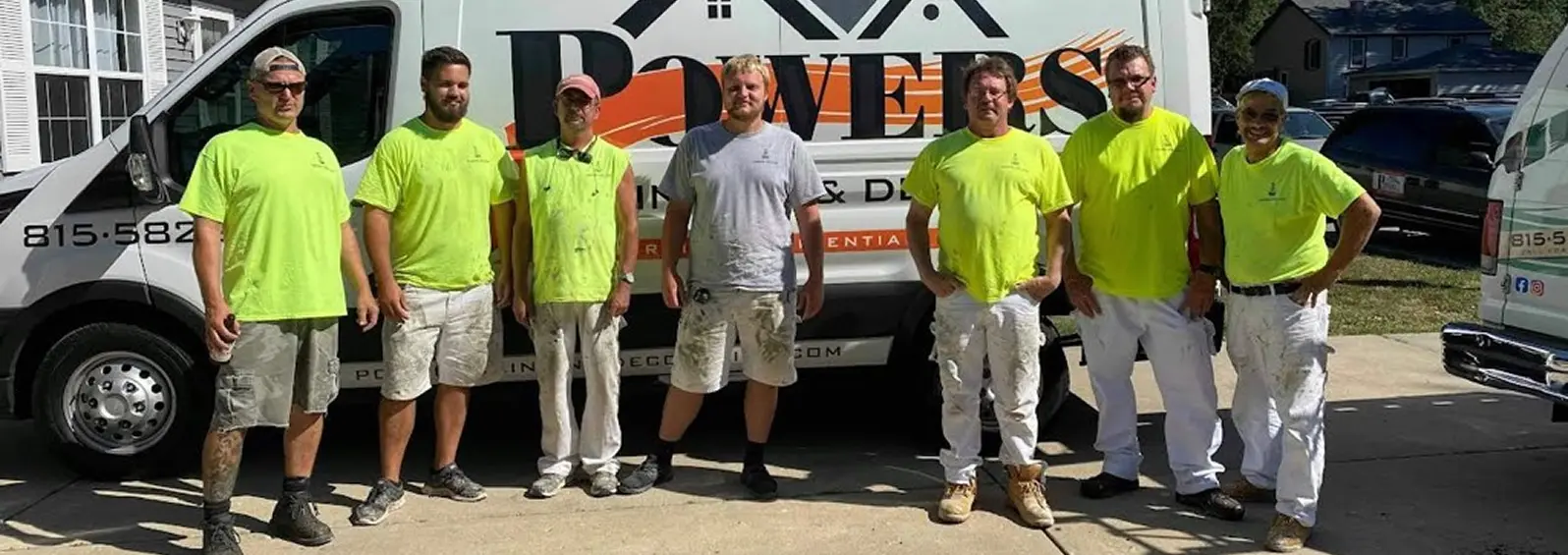 Powers Painting crew in high-visibility shirts in front of the company van