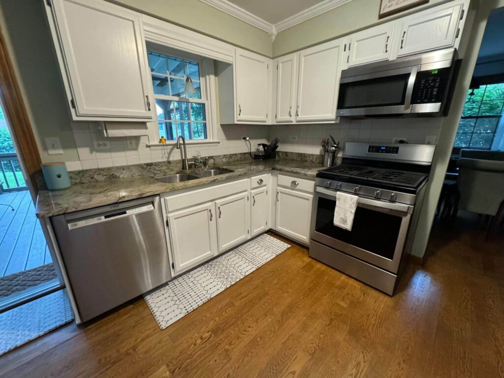 Kitchen with white painted cabinets, granite countertops and stainless steel appliances