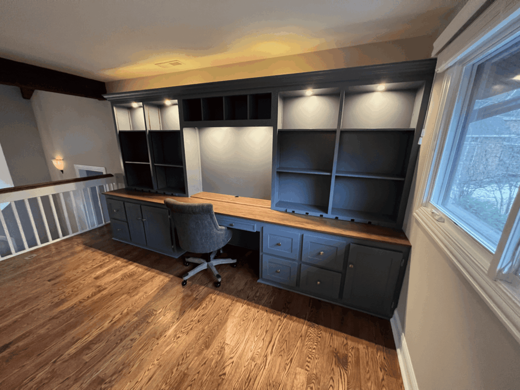 Home office with dark gray painted built-in desk and shelving
