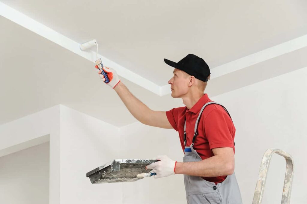 Painter rolling a ceiling edge with a cut-in brush in Channahon, Illinois