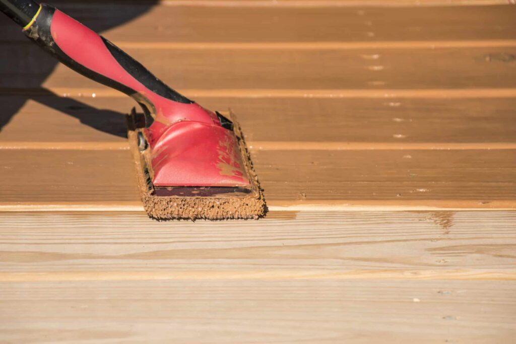 Sanding block smoothing wood deck boards before staining
