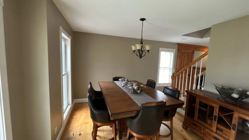 Dining room with warm beige walls, a wood table and chandelier