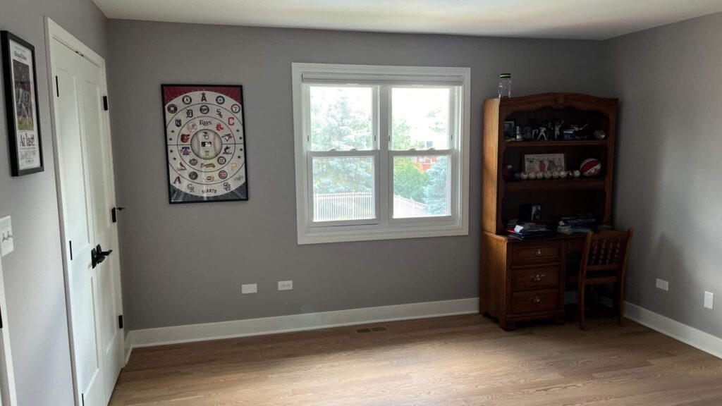 Room with newly painted gray walls drying beside a bright double window