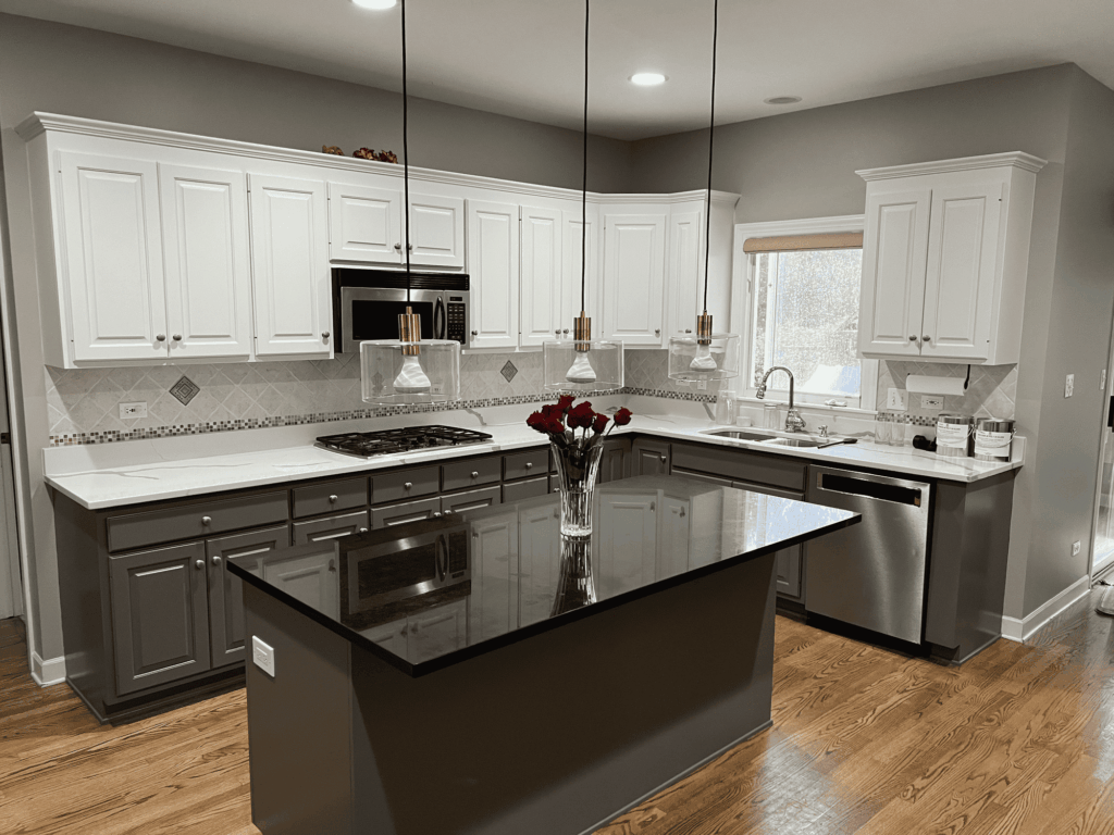 White kitchen cabinets with a gray painted island and black granite countertop