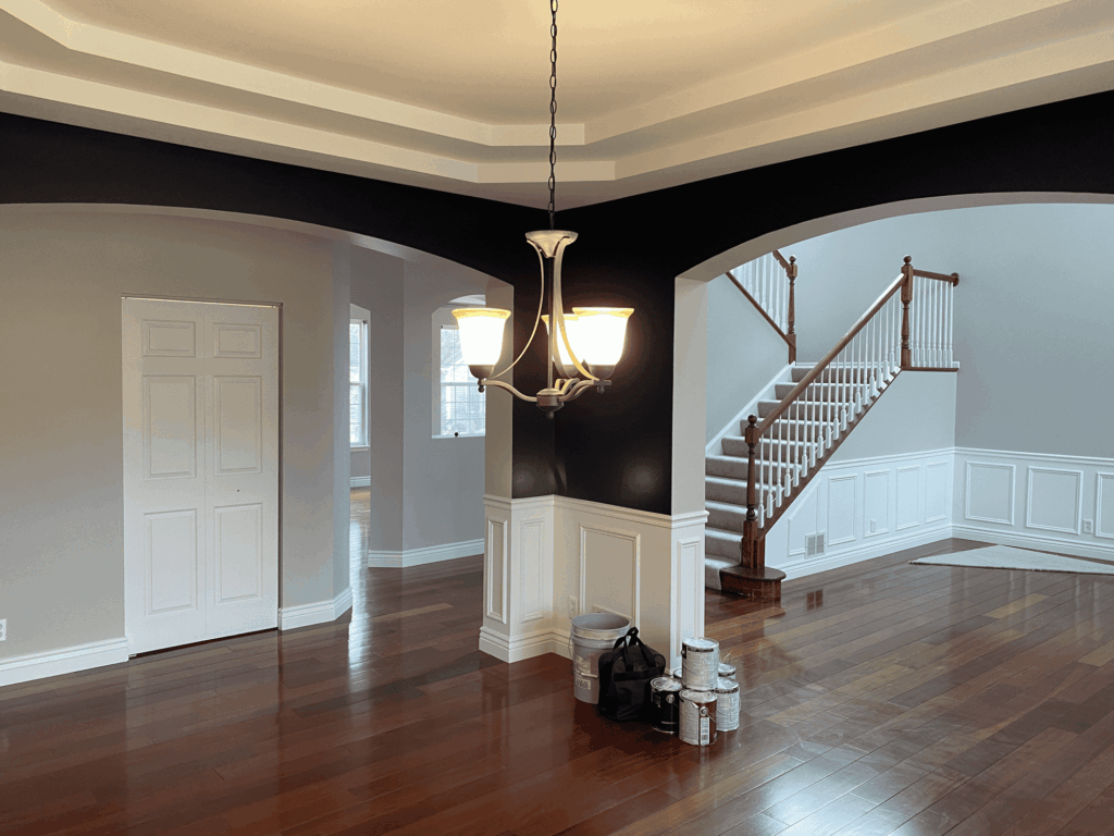 Empty room with a tray ceiling and staircase ready for interior painting