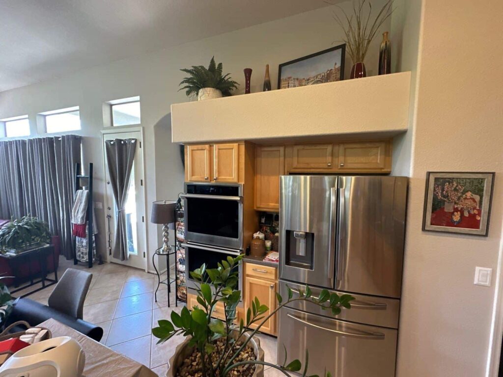 Kitchen with light wood cabinets opening onto a living room in Plainfield