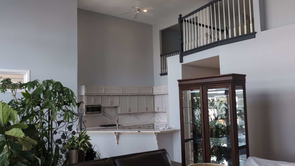Living room with a gray accent wall beneath an open loft railing