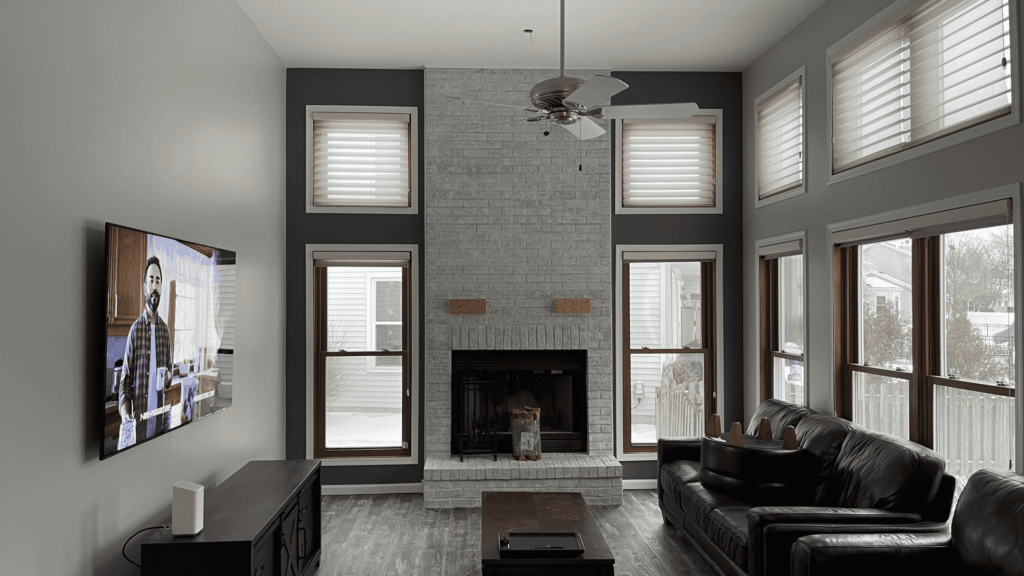 Modern living room with warm gray walls and a whitewashed brick fireplace