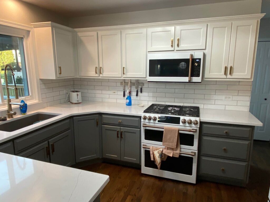 Two-tone kitchen with white upper cabinets and gray lower cabinets