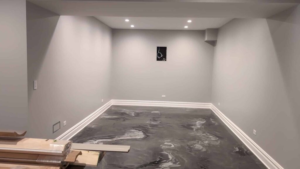 Basement room with freshly painted gray walls above a new epoxy floor coating
