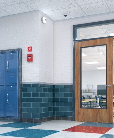 School hallway with blue lockers, teal tile wainscot and white painted walls