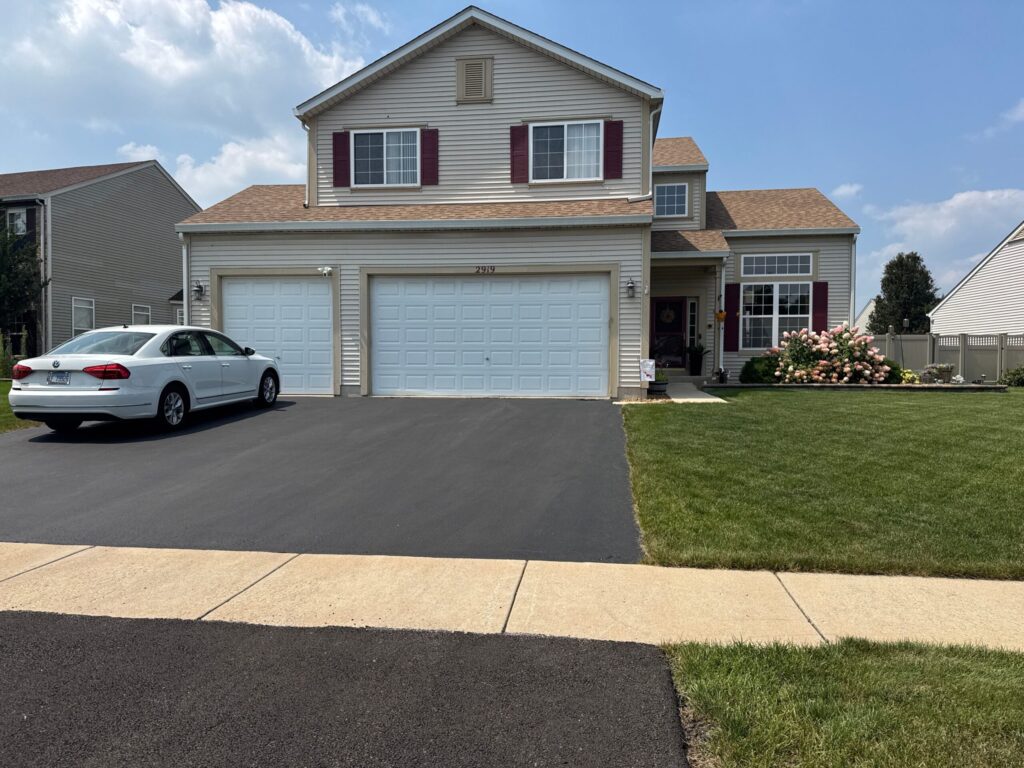 Two-story home with cream siding and white garage doors painted in Channahon, Illinois