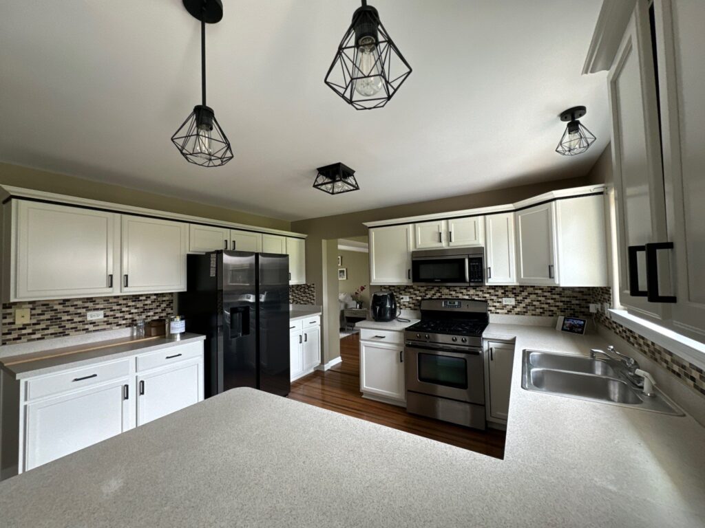 White U-shaped kitchen cabinets with a mosaic backsplash after careful prep work