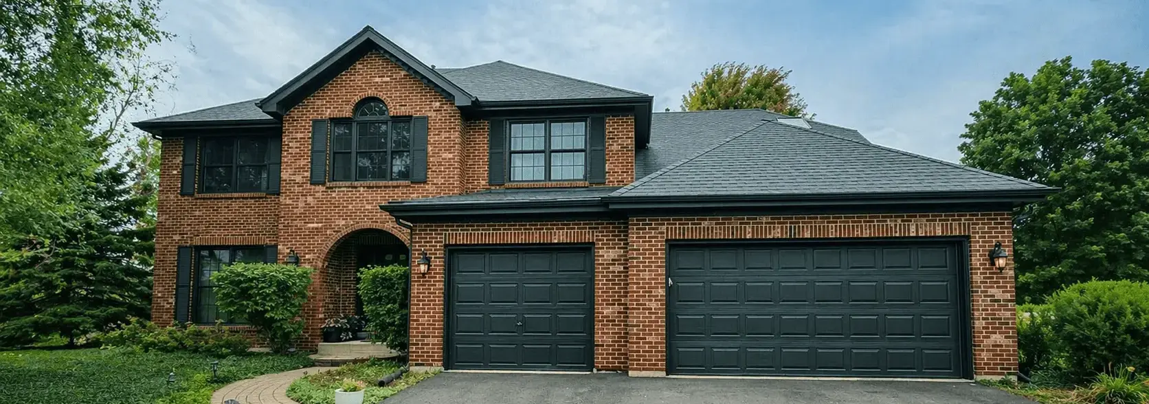 Two-story brick home with newly painted dark garage doors and trim in Naperville, Illinois