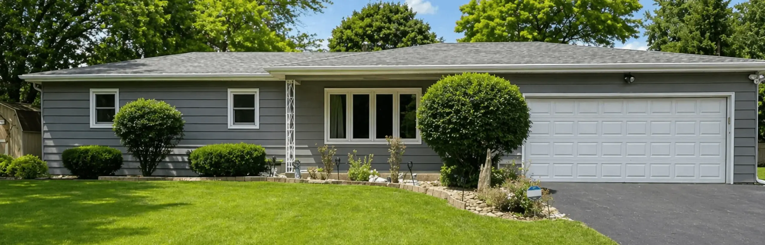 Light gray ranch home with white garage door and trim repainted in Channahon, Illinois