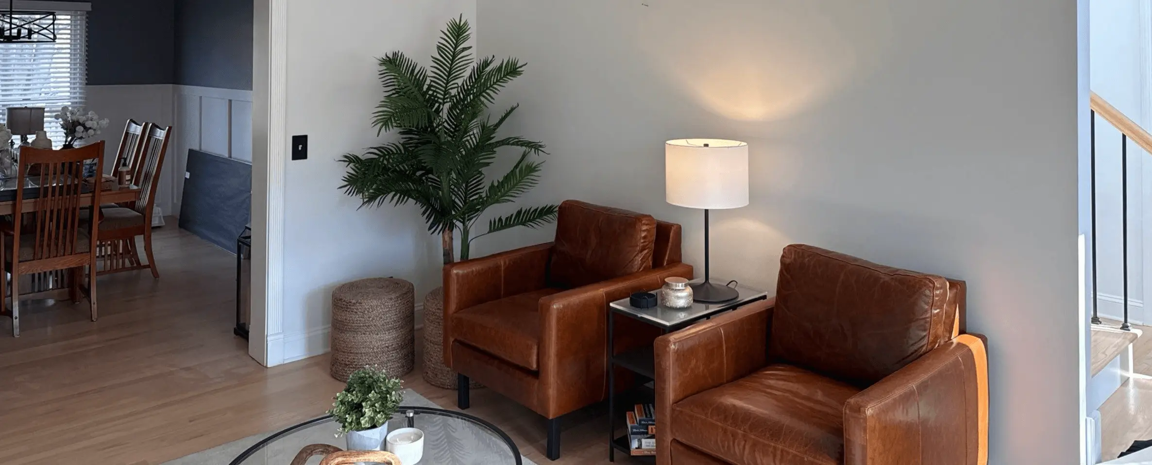 Living room with freshly painted light gray walls, leather armchairs and an open dining area